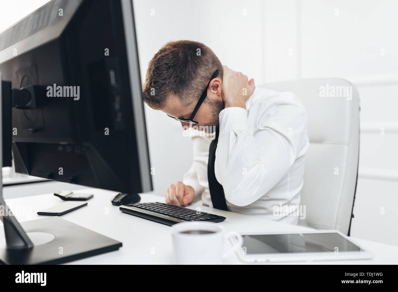 Office worker with back pain from sitting at desk all day Stock Photo