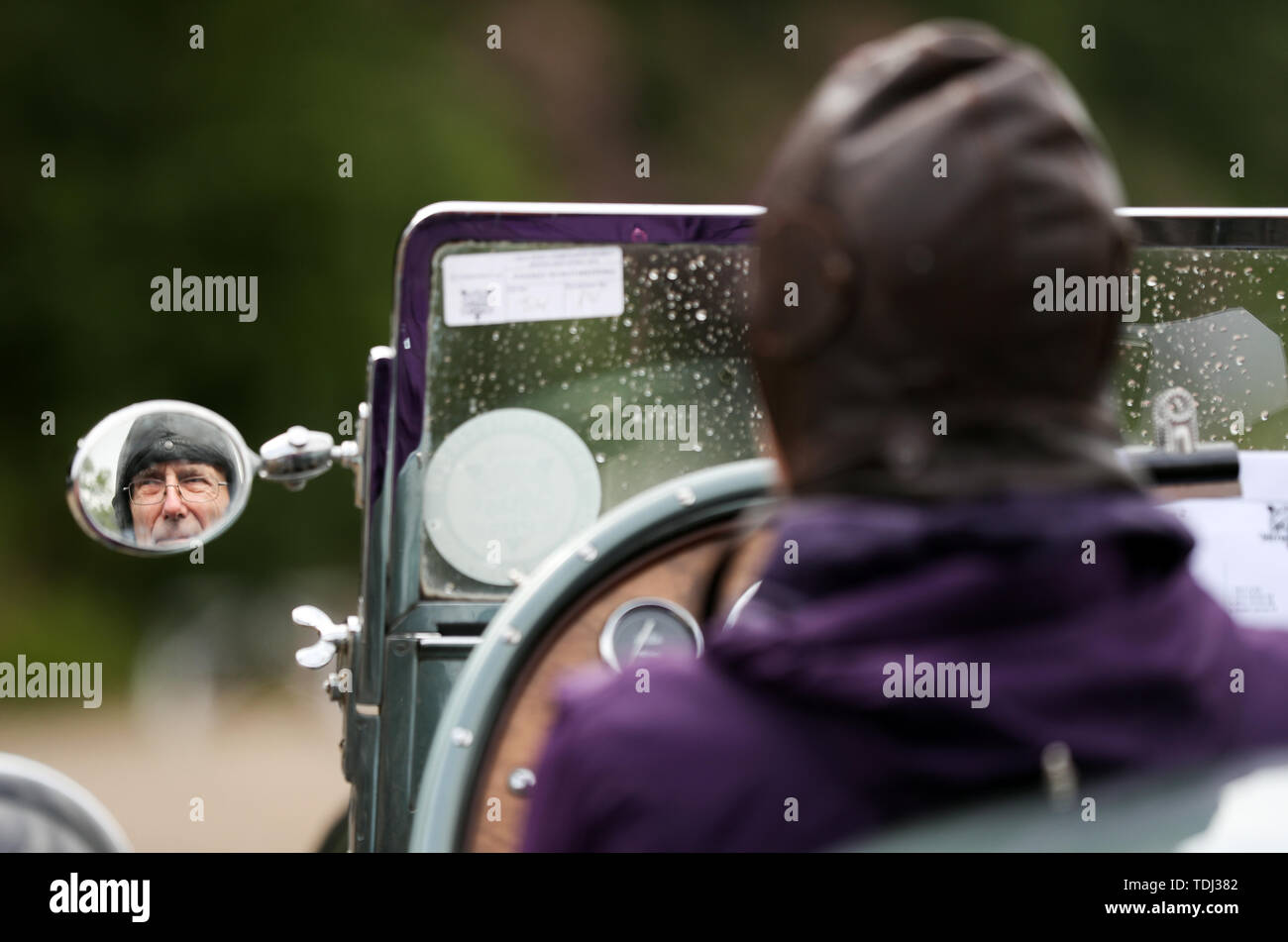 A driver of a 1935 Hudson Spikins Special is reflected in one of his wing mirrors during the Brooklands Double Twelve Motorsport Festival at Brooklands Museum, in Weybridge, Surrey. Stock Photo