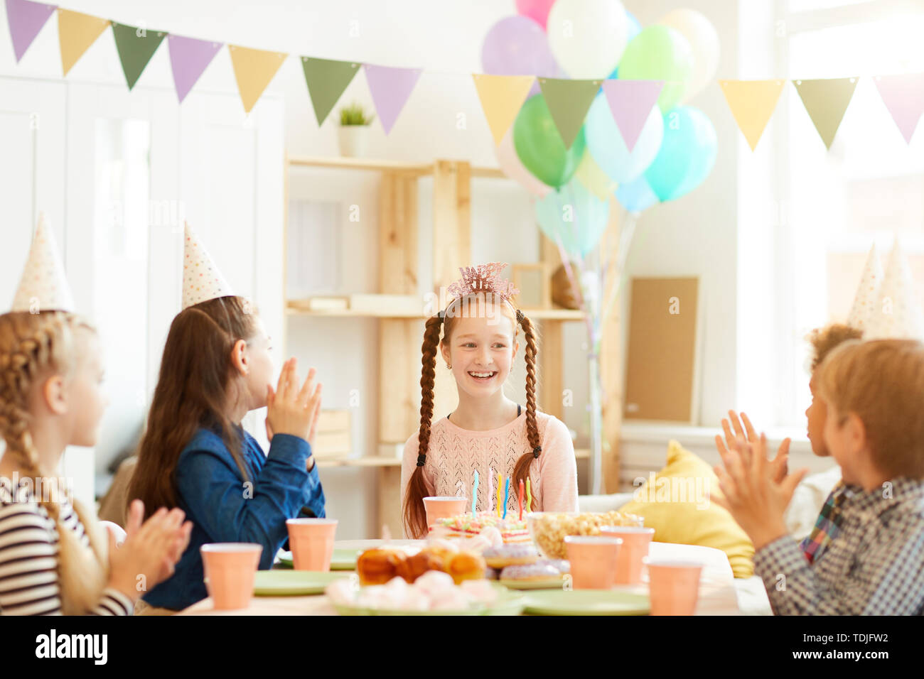 Group of children celebrating birthday at party table with happy red ...