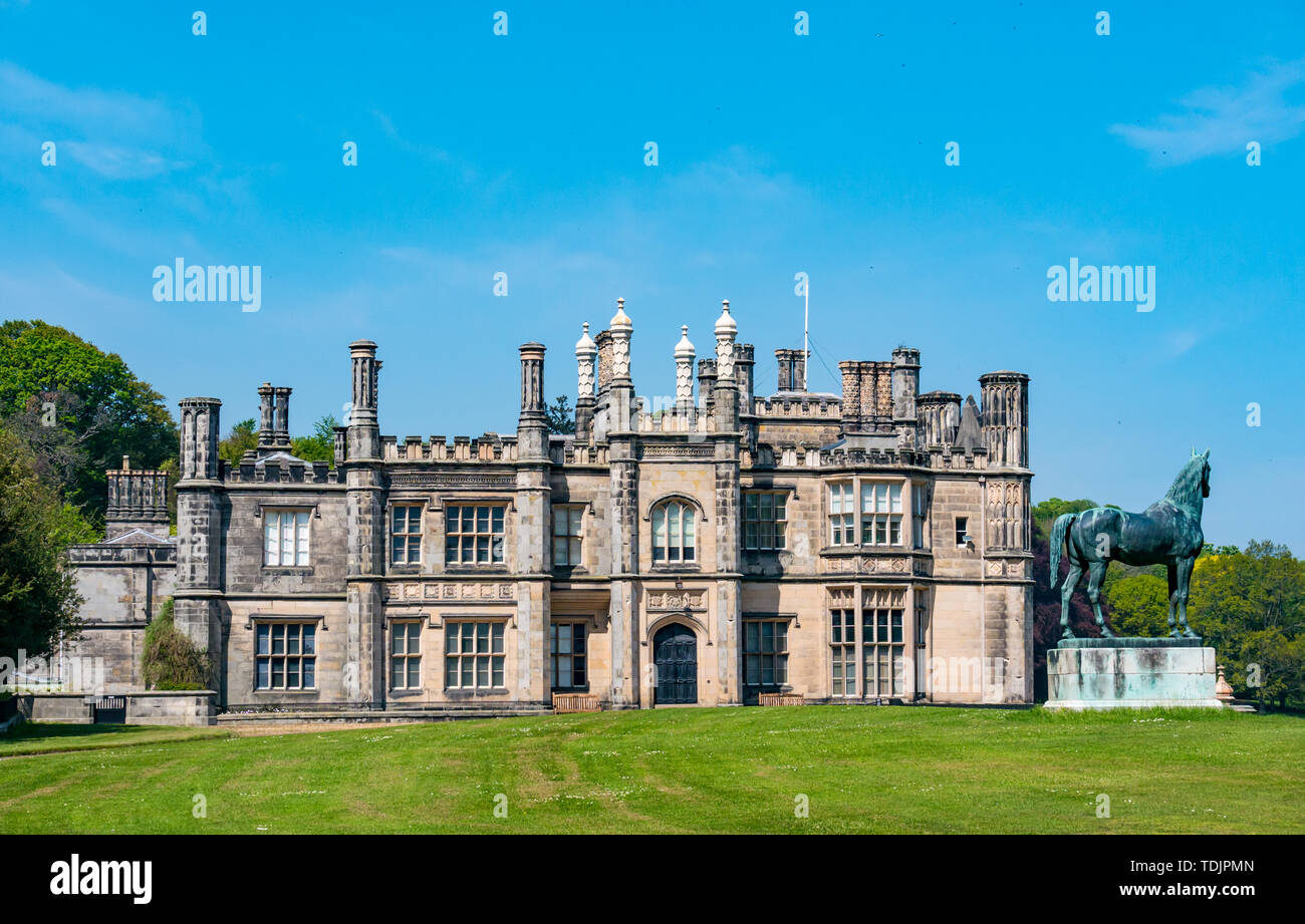 Gothic revival mansion, Dalmeny House, with King Tom race horse stallion statue, South Queensferry, Scotland, UK Stock Photo