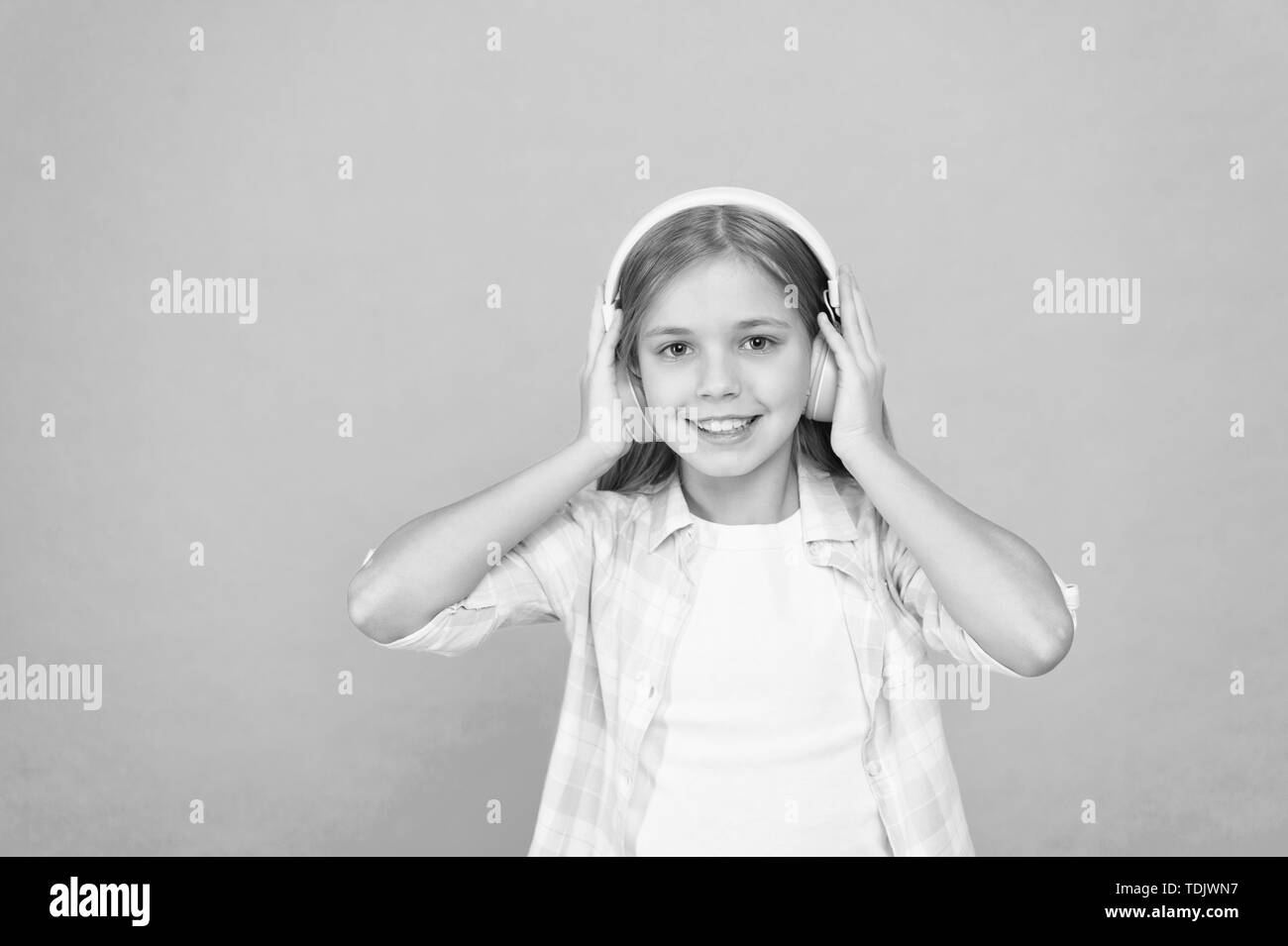 Clear sound. Girl child listen music with modern headphones. Kid little