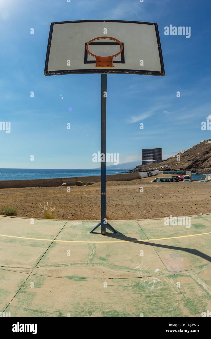 Basketball backboard with basket on the old sports field. Huge Abandoned  building in front of the ocean in the far background. Tenerife. Wide angle,  f Stock Photo - Alamy