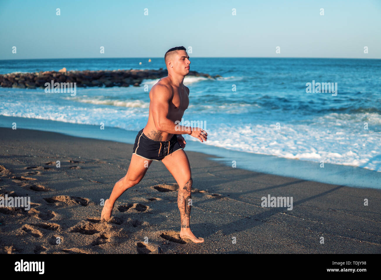 Tattooed bodybuilder sexy male coach at the beach Stock Photo - Alamy