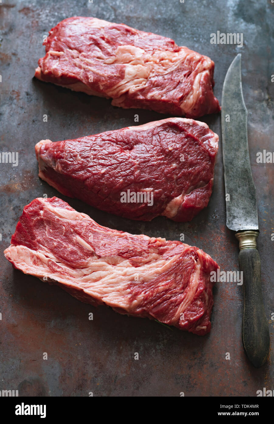 Raw black angus prime beef steak variety on dark metallic background Stock Photo