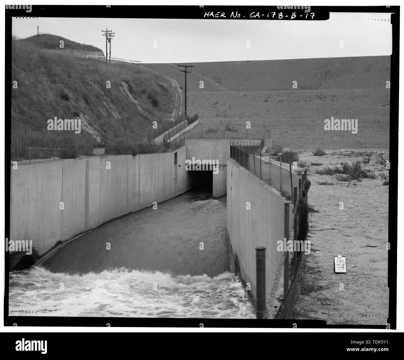 OUTLET STRUCTURE, LOOKING NORTH. NOTE ALSO THE DRAINAGE CHANNEL AND  CONCRETE FLUME ALONG WEST EDGE OF EMBANKMENT. - Prado Dam, Outlet Works,  Santa Ana River near junction of State Highways 71 and