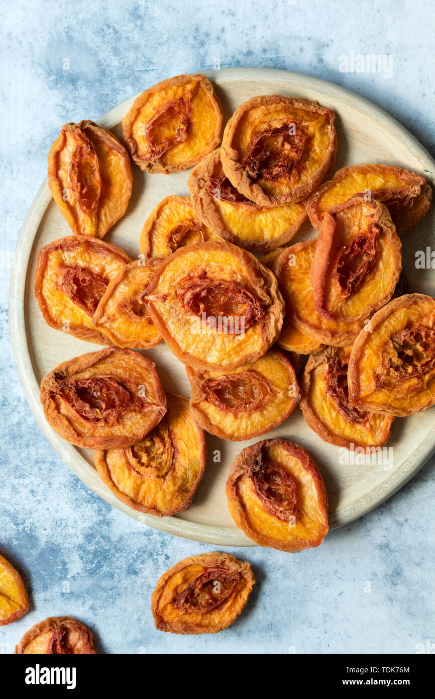 Dried peach halves on a wooden platter Stock Photo Alamy
