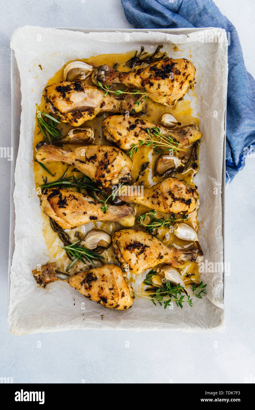 Oven baked chicken legs with herbs and garlic in a baking sheet