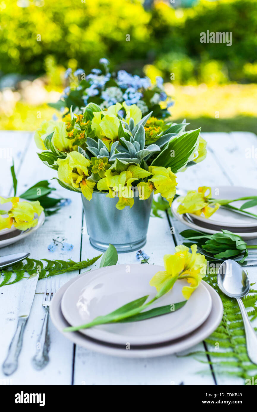 Wedding decoration in rustic style. Florist design. Bouquets of irises and forget-me-nots. Outdoor Wedding Stock Photo