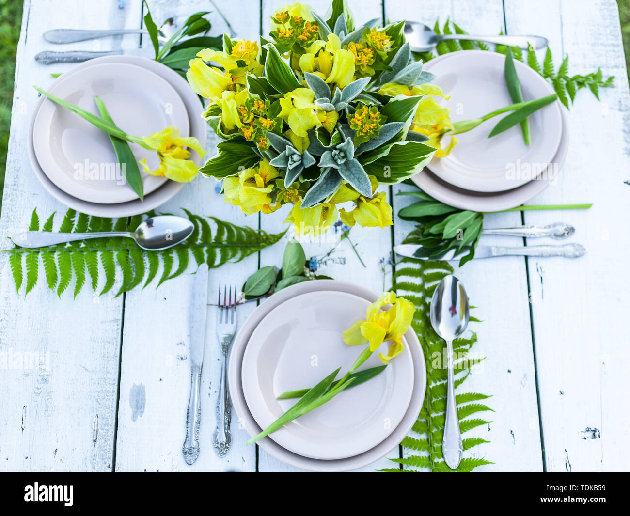 Wedding decoration in rustic style. Florist design. Bouquets of irises and forget-me-nots. Outdoor Wedding Stock Photo