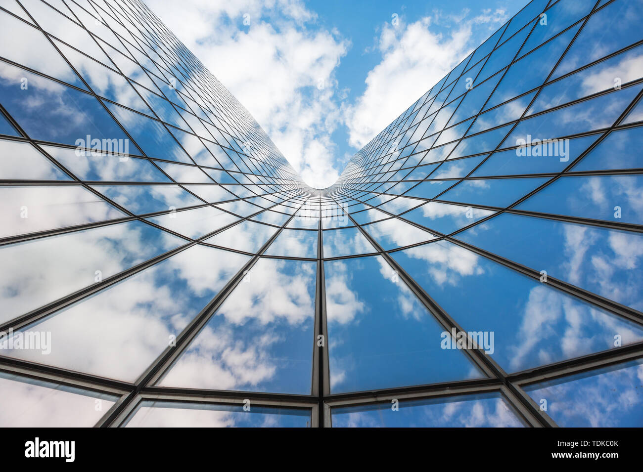 A reflection of the blue sky and white clouds on the glass curtain wall ...