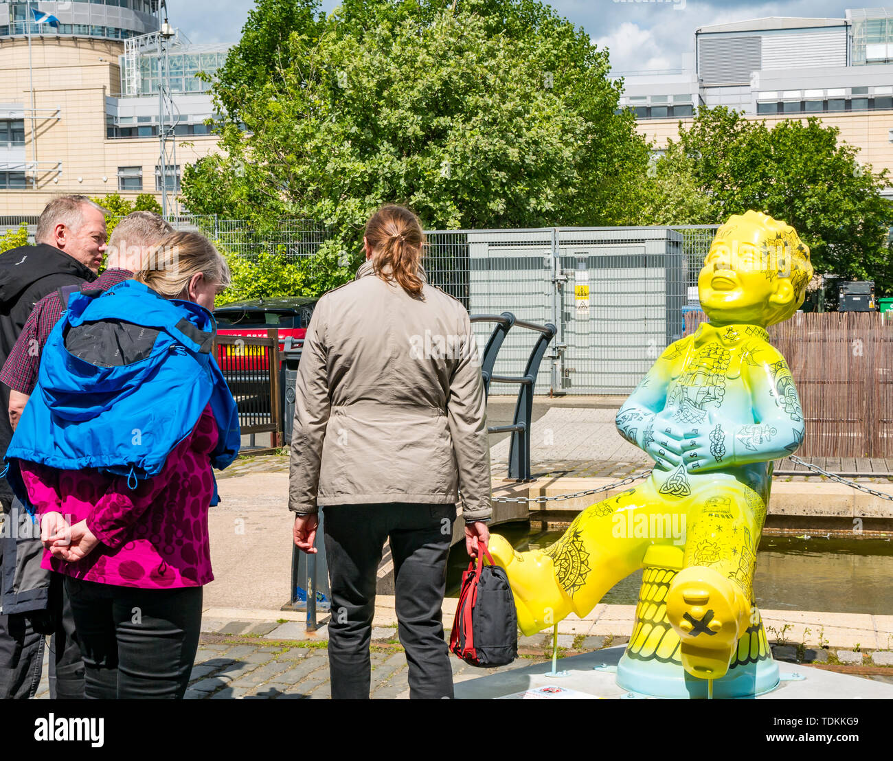 Leith, Edinburgh, Scotland, United Kingdom, 17 June 2019. Oor Wullie's Big Bucket Trail: An art trail of 200 Oor Wullie sculptures appear in Scottish cities in a mass arts event that lasts until August 30th. Oor Wullie is an iconic Scottish cartoon character from the Sunday Post newspaper. The sculptures will be auctioned to raise money for Scotland’s children’s hospital charities. There are 5 in the Leith area, and 60 in Edinburgh altogether.  Sailoor Wullie by The Leith Agency with tourists looking Stock Photo