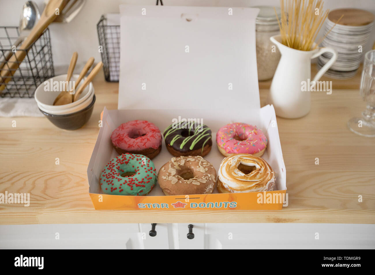 Box with doughnuts on table Stock Photo
