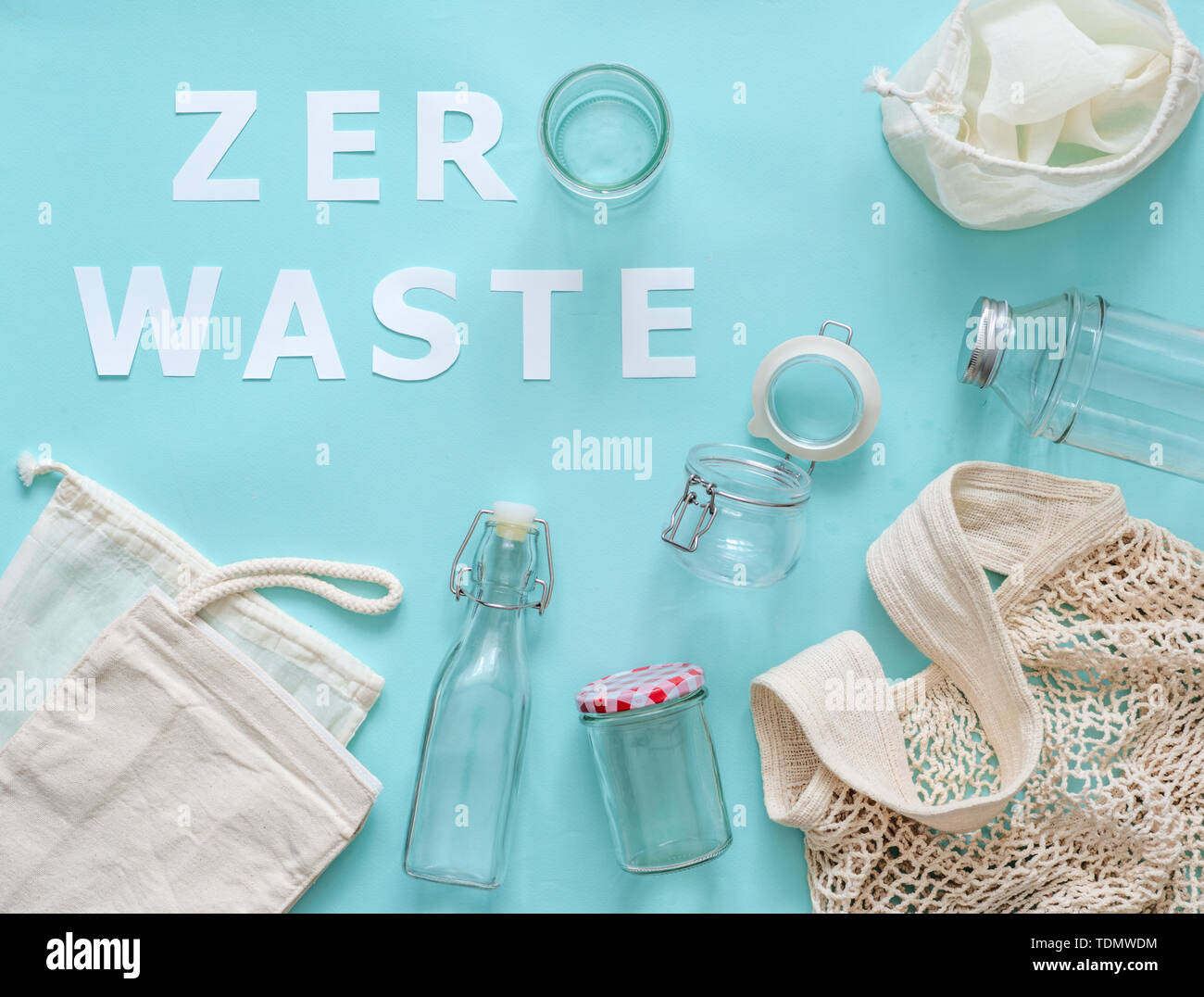 Zero waste concept. Textile eco bags, glass jar and bottle on blue