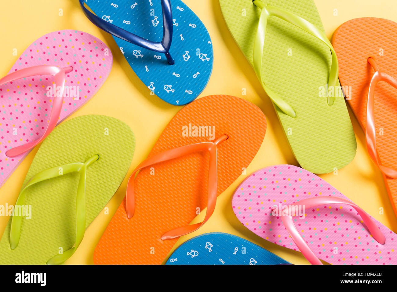 many colored flip flops on yellow background. Copy space top view Stock ...