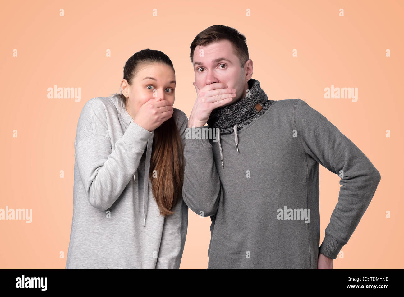 man and woman laughing and covering mouth with hand Stock Photo