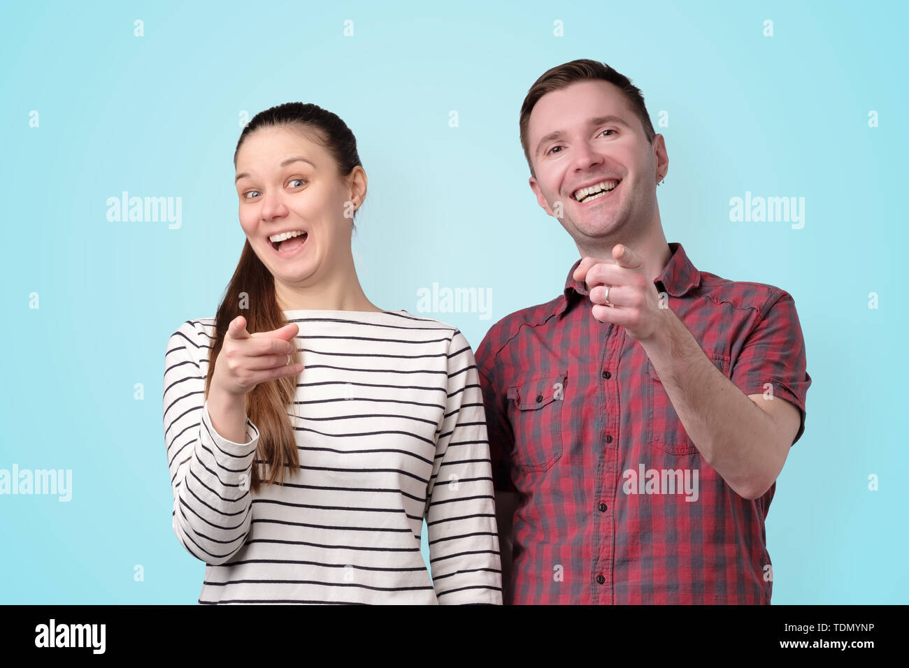couple man and woman laughing pointing at you Stock Photo