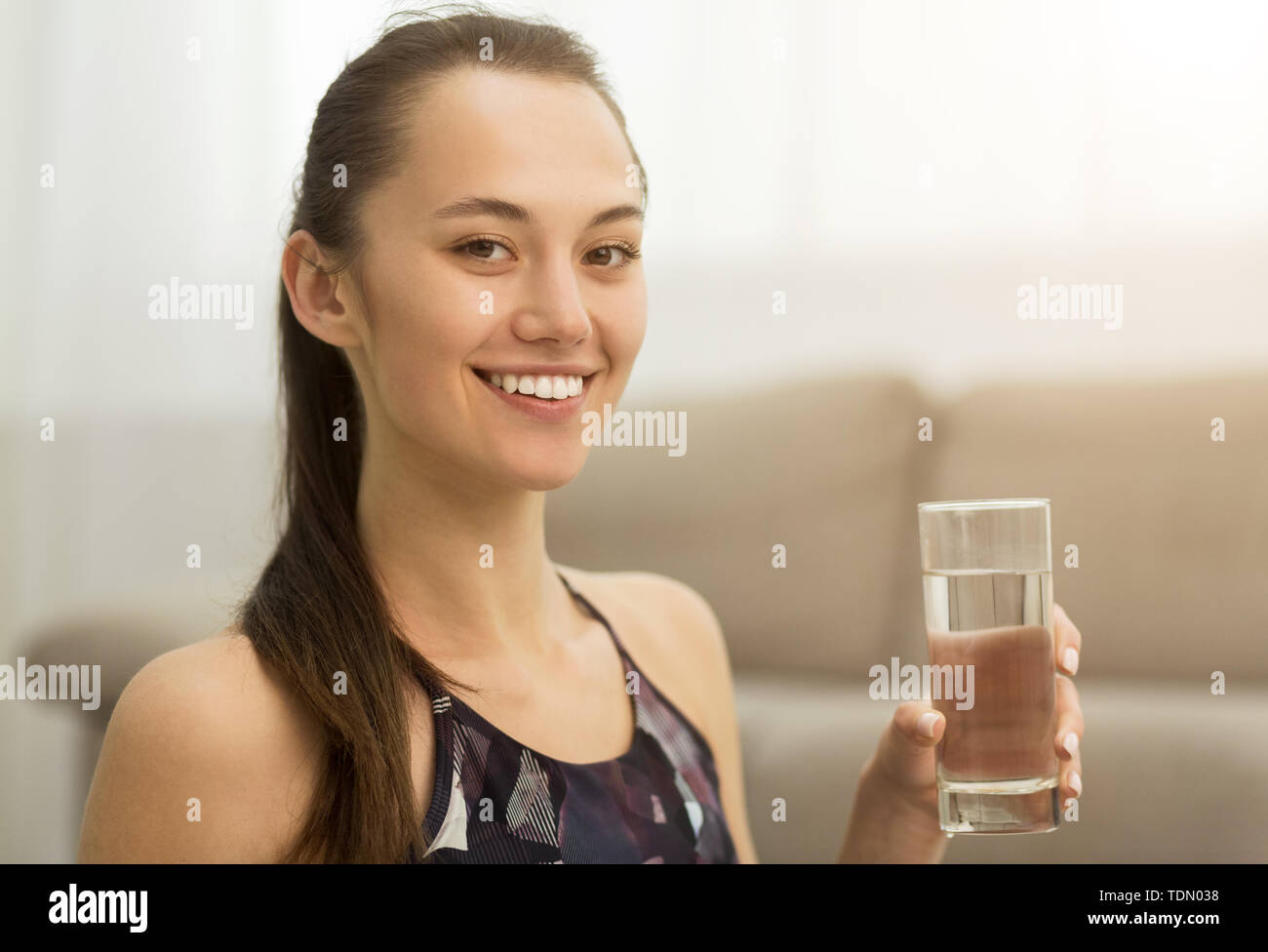 Healthcare. Girl drinking clean mineral water, side view Stock Photo