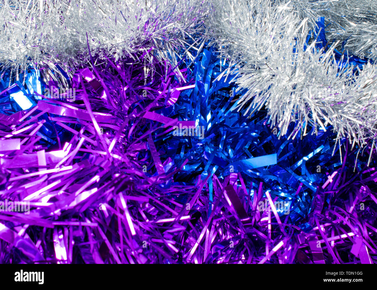 A pile of tinsel in silver, purple and blue Stock Photo Alamy