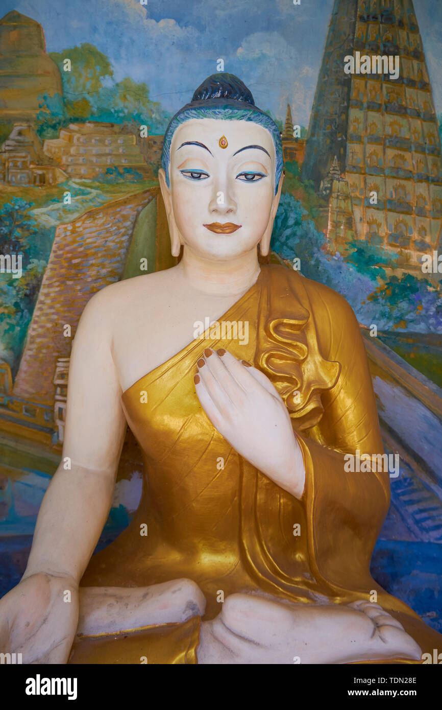 A lovely female Buddha statue with painted mural background at the