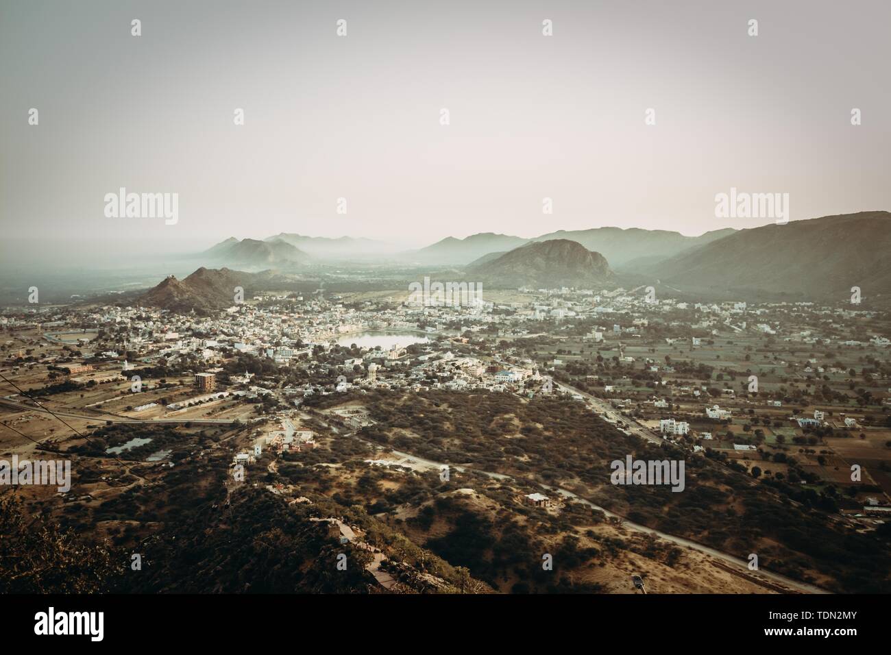 Aerial wide shot of a suburban town in the middle of a large valley ...