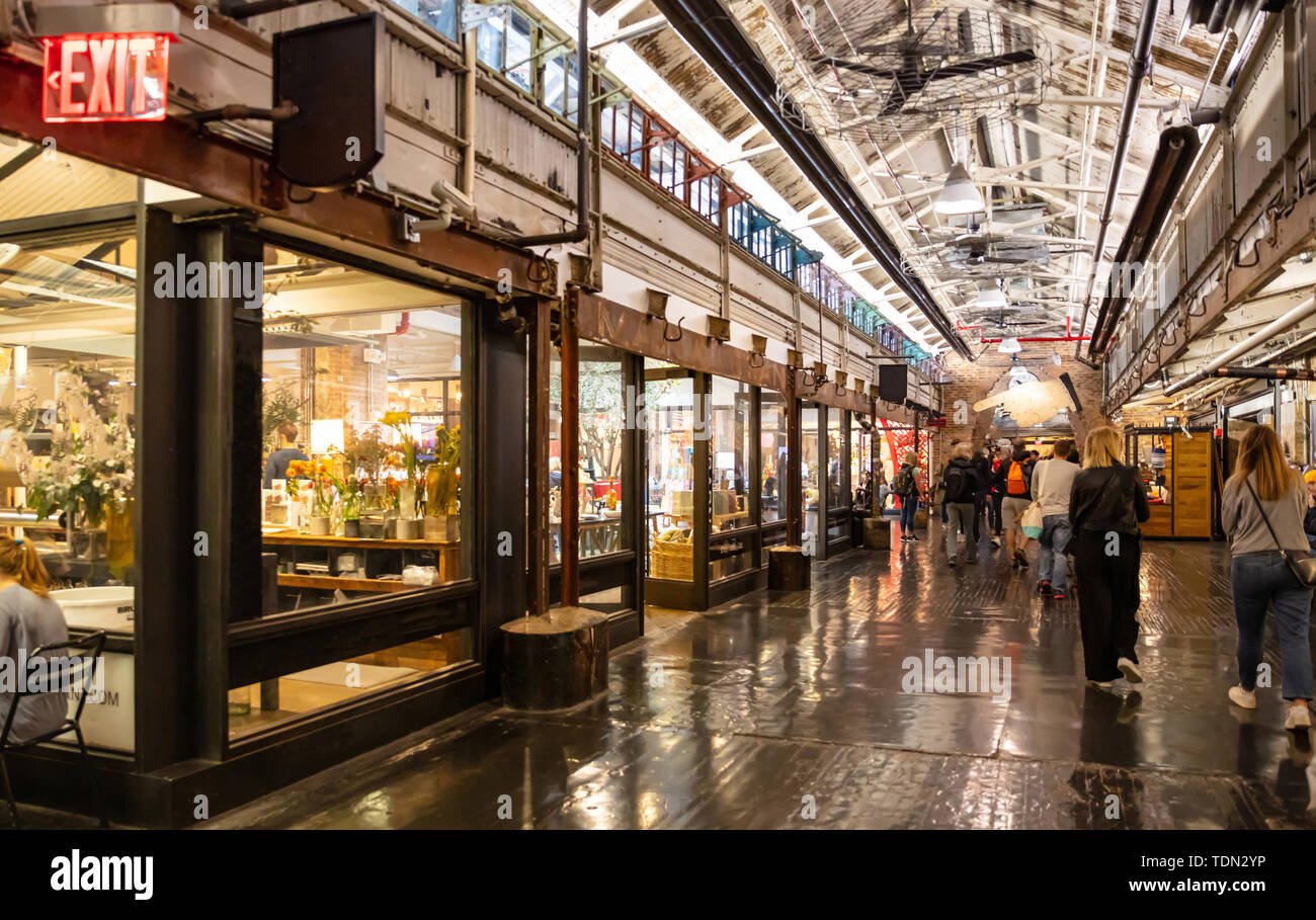 New York, Chelsea market. Interior view of the entrance hall, people walking, illuminated stores Stock Photo