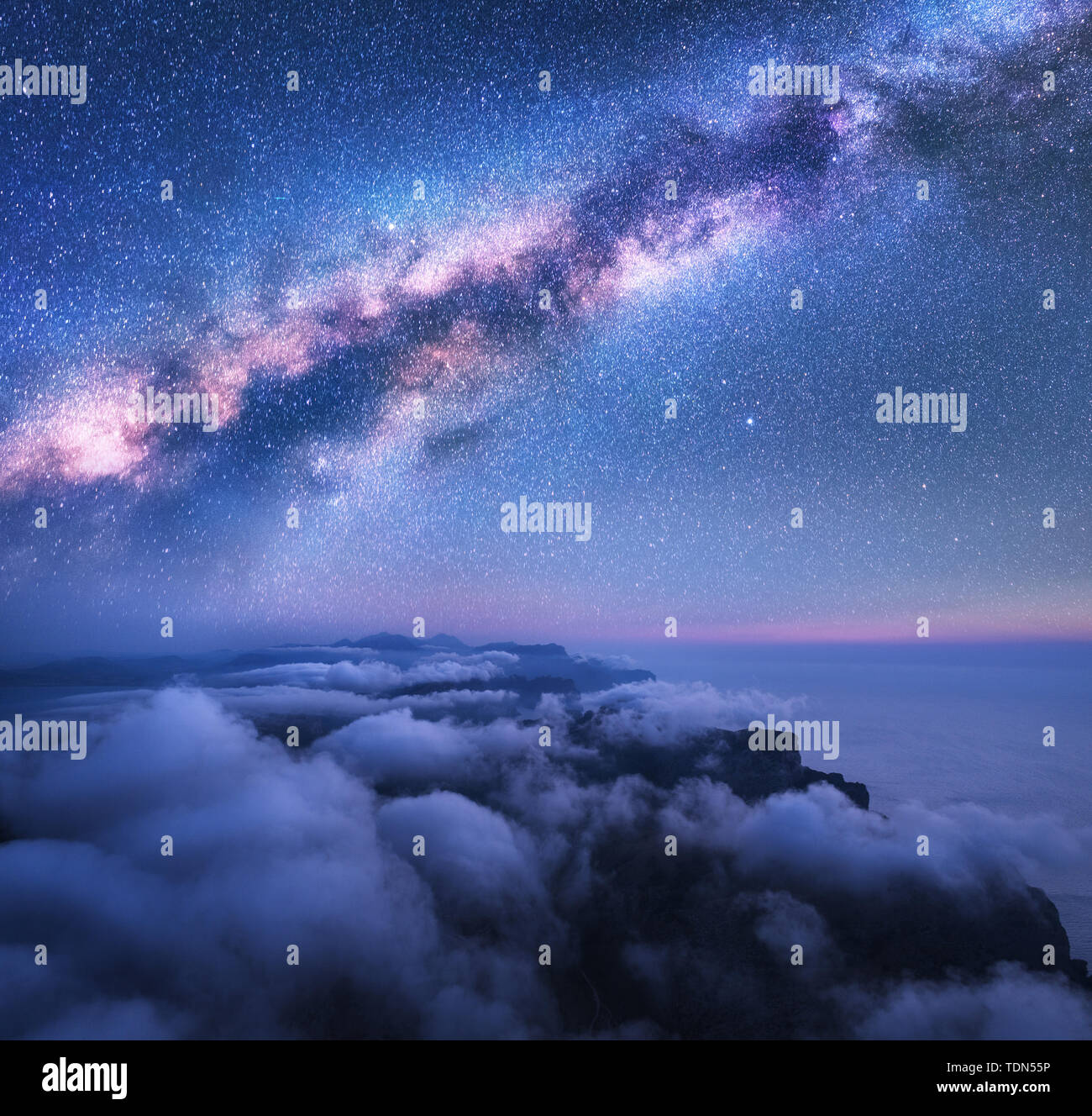 Milky Way over the low clouds and sea coast at starry night Stock Photo