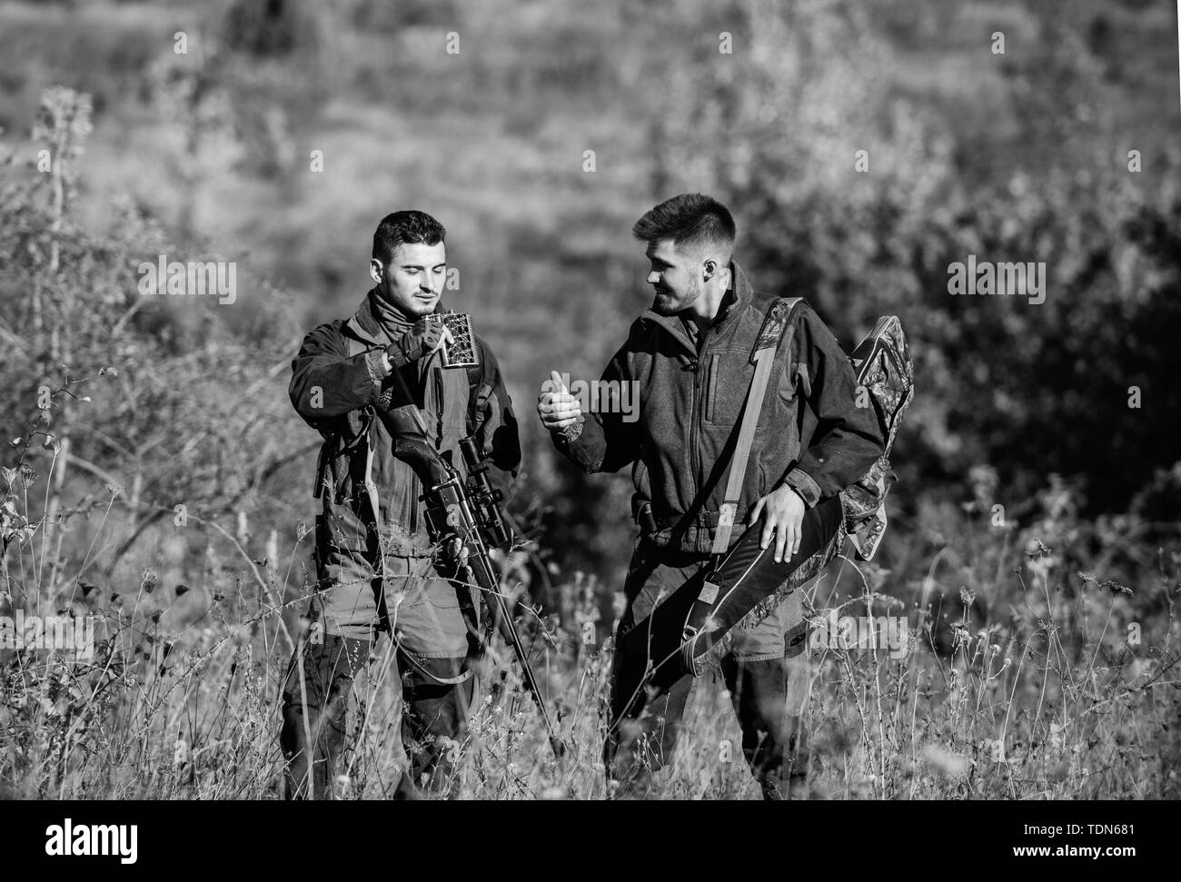 Army forces. Camouflage. Friendship of men hunters. Hunting skills and weapon equipment. How turn hunting into hobby. Military uniform. Man hunters with rifle gun. Boot camp. Hunters gamekeepers. Stock Photo