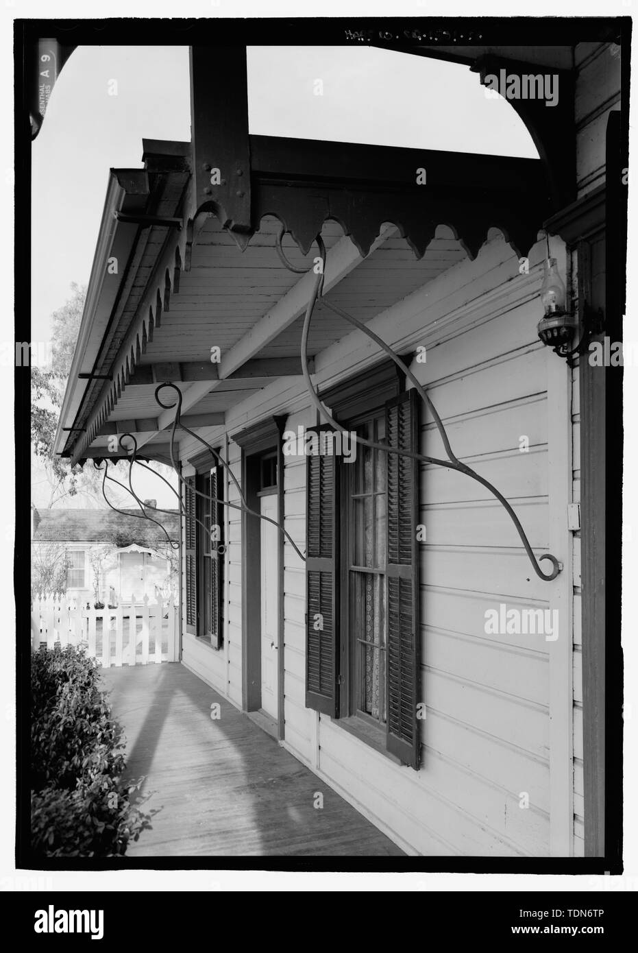 Perspective view of wood frame addition with original iron scrolls on