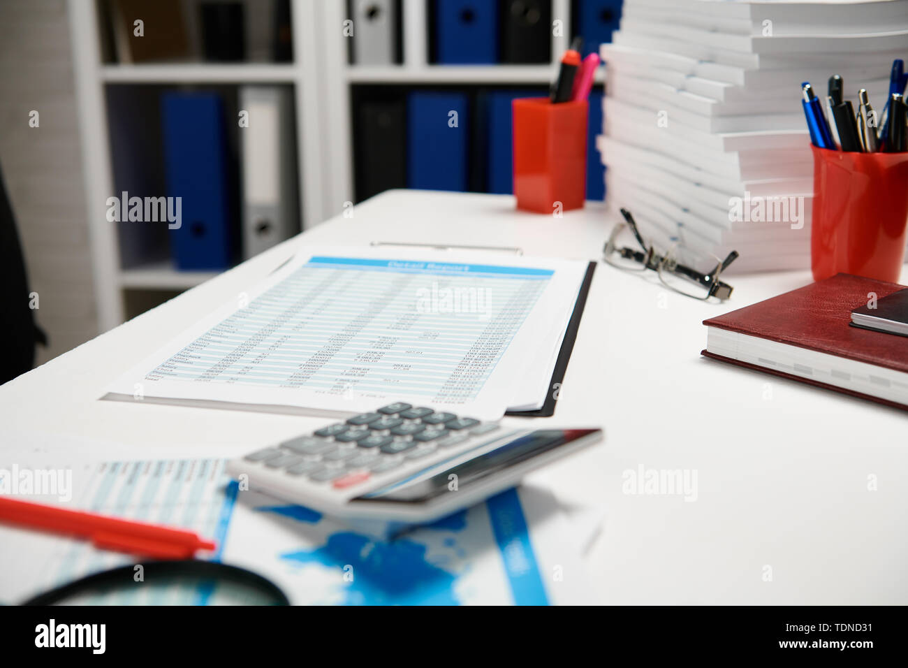 Office workplace table closeup with reports and shelves. Business