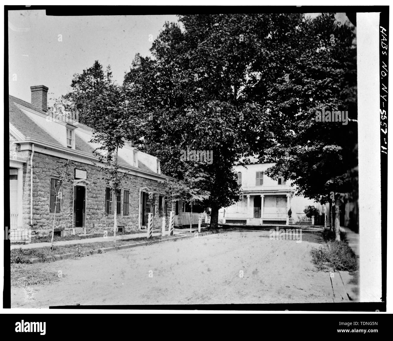 Photocopy of old photo shows the front facade partially hidden by trees. It dates from circa 1883 and includes the porch with Ionic columns. From an unknown source. - John Tremper House, 3 North Front Street, Kingston, Ulster County, NY Stock Photo