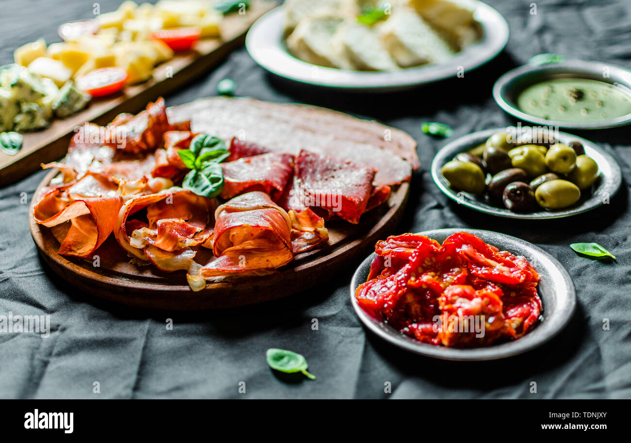 Italian cold meat and cheese antipasti delicatessen platter on black