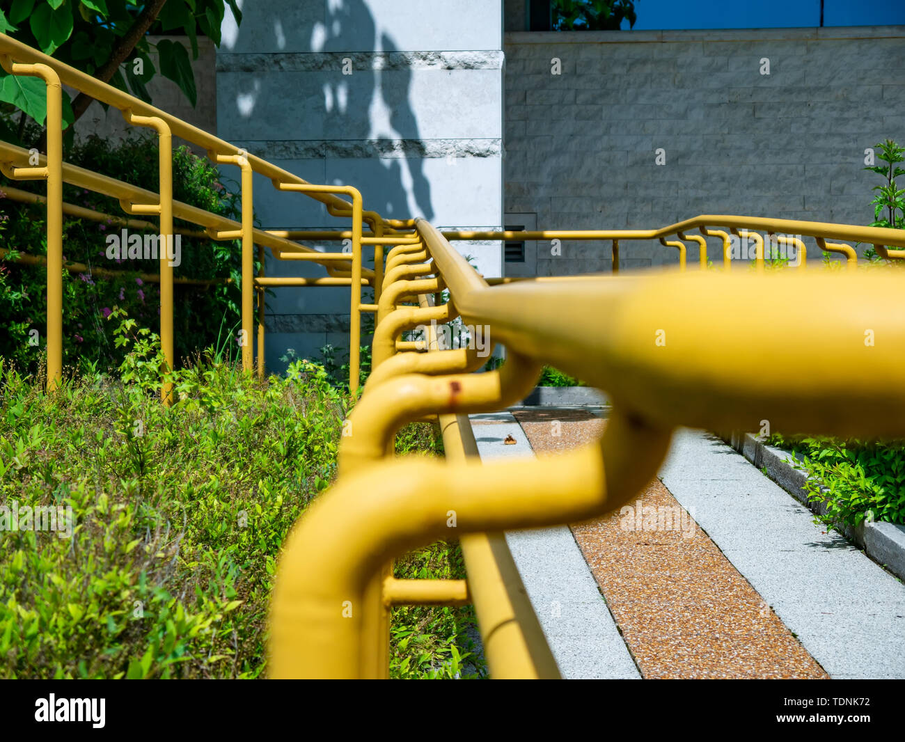 View on a rusty yellow railing of a sidewalk on a sunny day Stock Photo ...