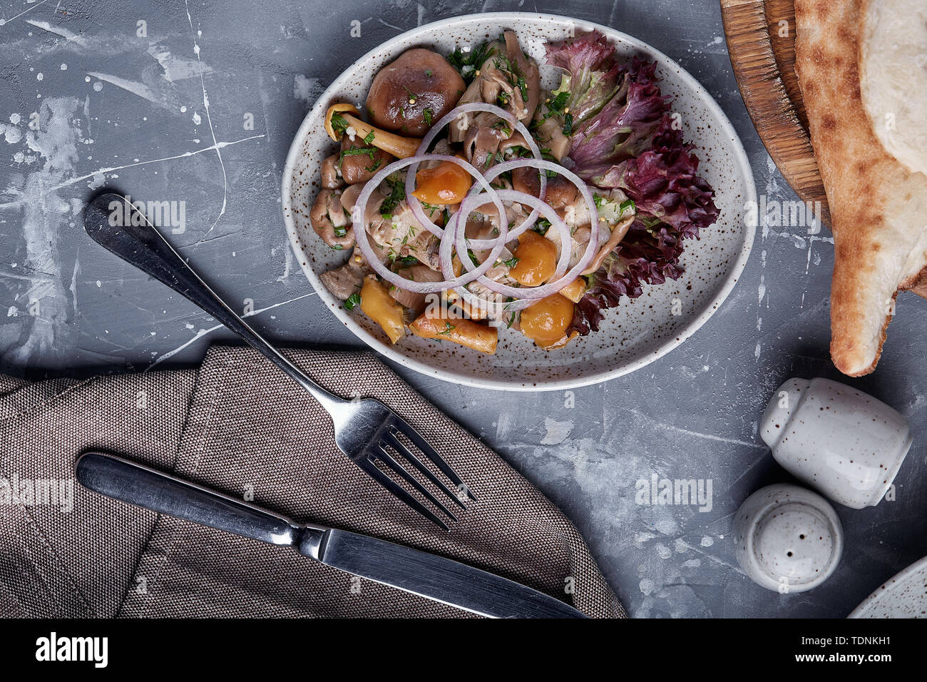 marinated mushrooms and onions in a plate on a grey background Stock