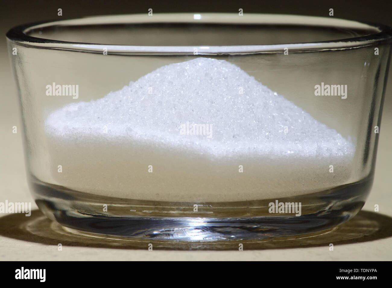 Closeup of a pile of sugar in a cup-sized glass container Stock Photo