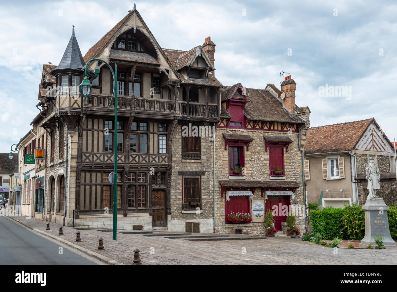 Historic building on Rue Grande with war memorial on right in Moret-sur-Loing, Seine-et-Marne, Île-de-France region of north-central France Stock Photo