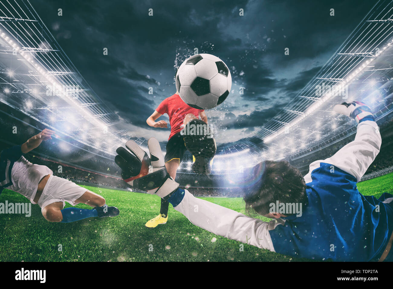 Close up of a football action scene with competing soccer players at the stadium during a night match Stock Photo