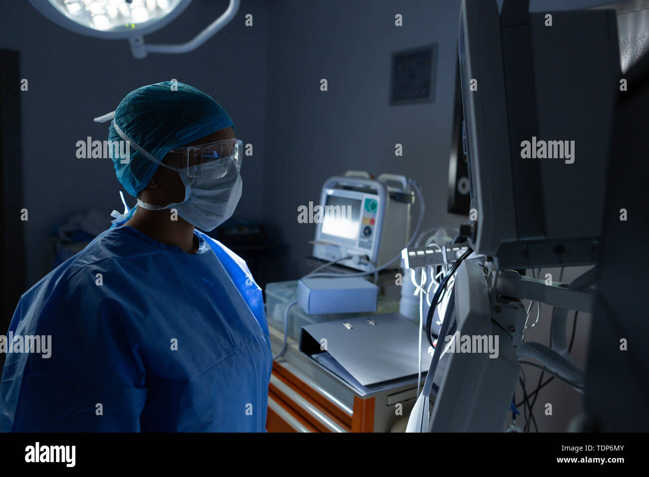 Surgeon Using Monitor Female surgeon looking at monitor in operation theater Stock Photo - Alamy
