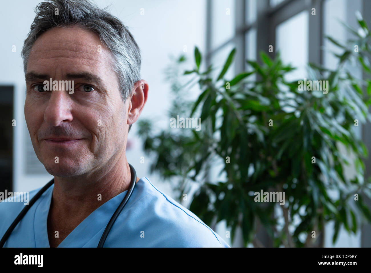 Male doctor looking at camera in corridor Stock Photo - Alamy