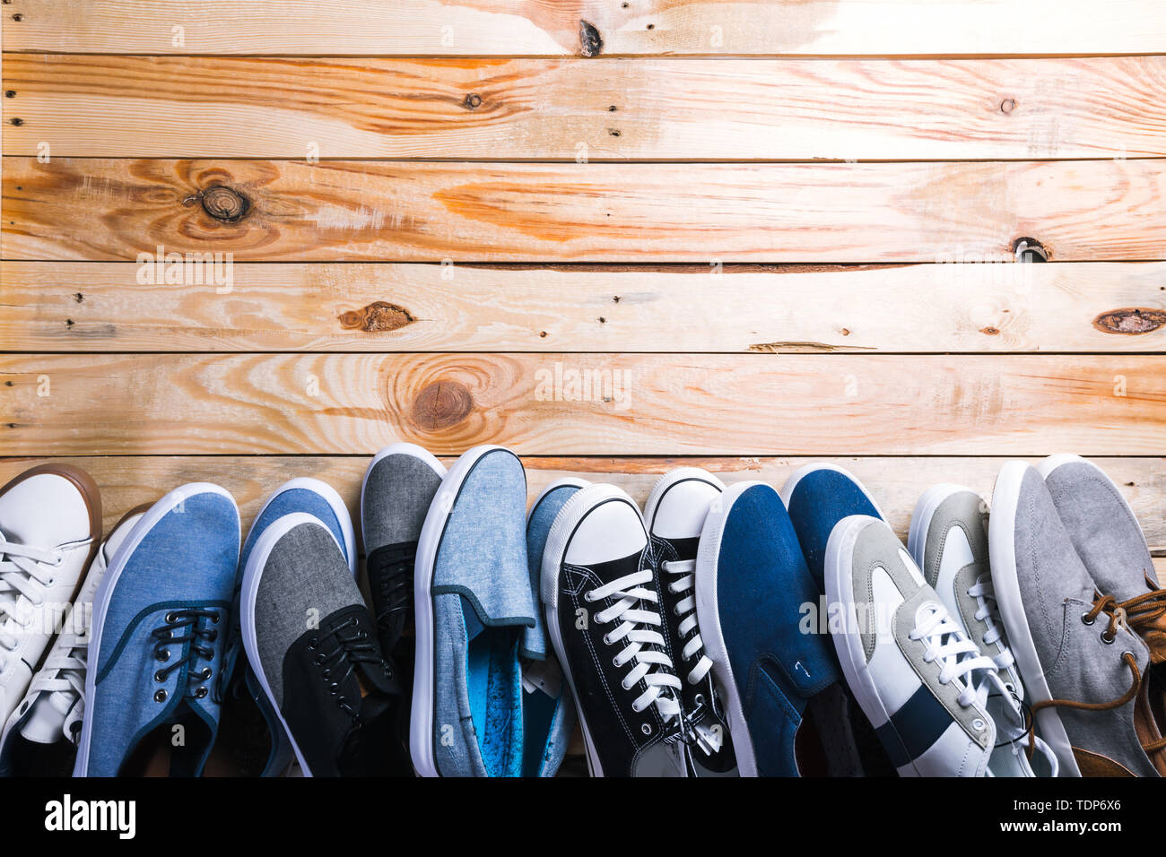 Various pairs of sneakers laid on the wooden floor background Stock ...