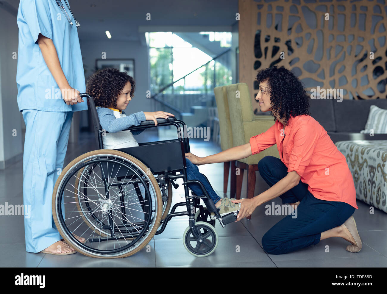 Mother consoling her disabled son in the lobby at hospital Stock Photo ...