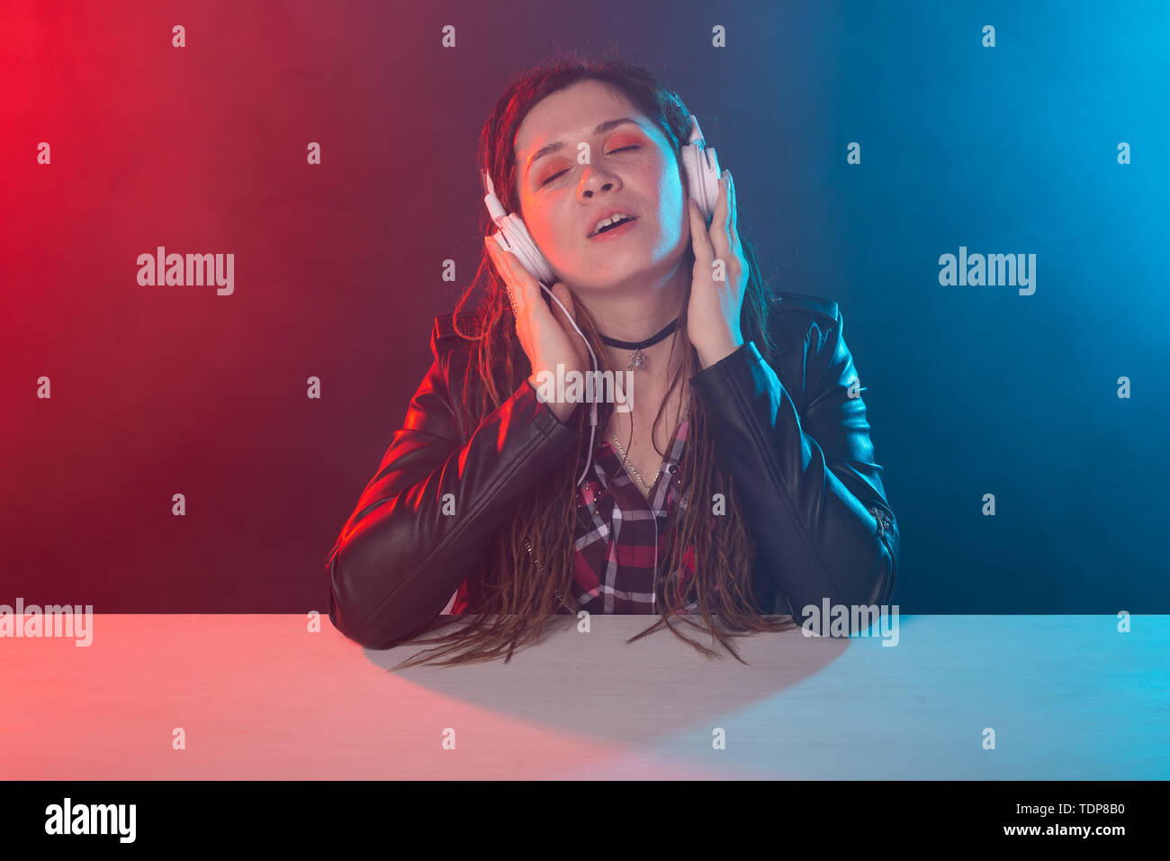 Meloman, music and people concept - young woman with dreadlocks listen to the music and enjoy it Stock Photo