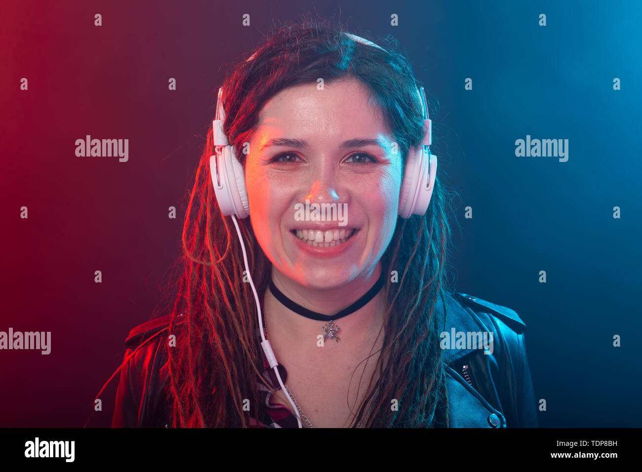 Meloman, music and people concept - young woman with dreadlocks listen to the music and enjoy it Stock Photo