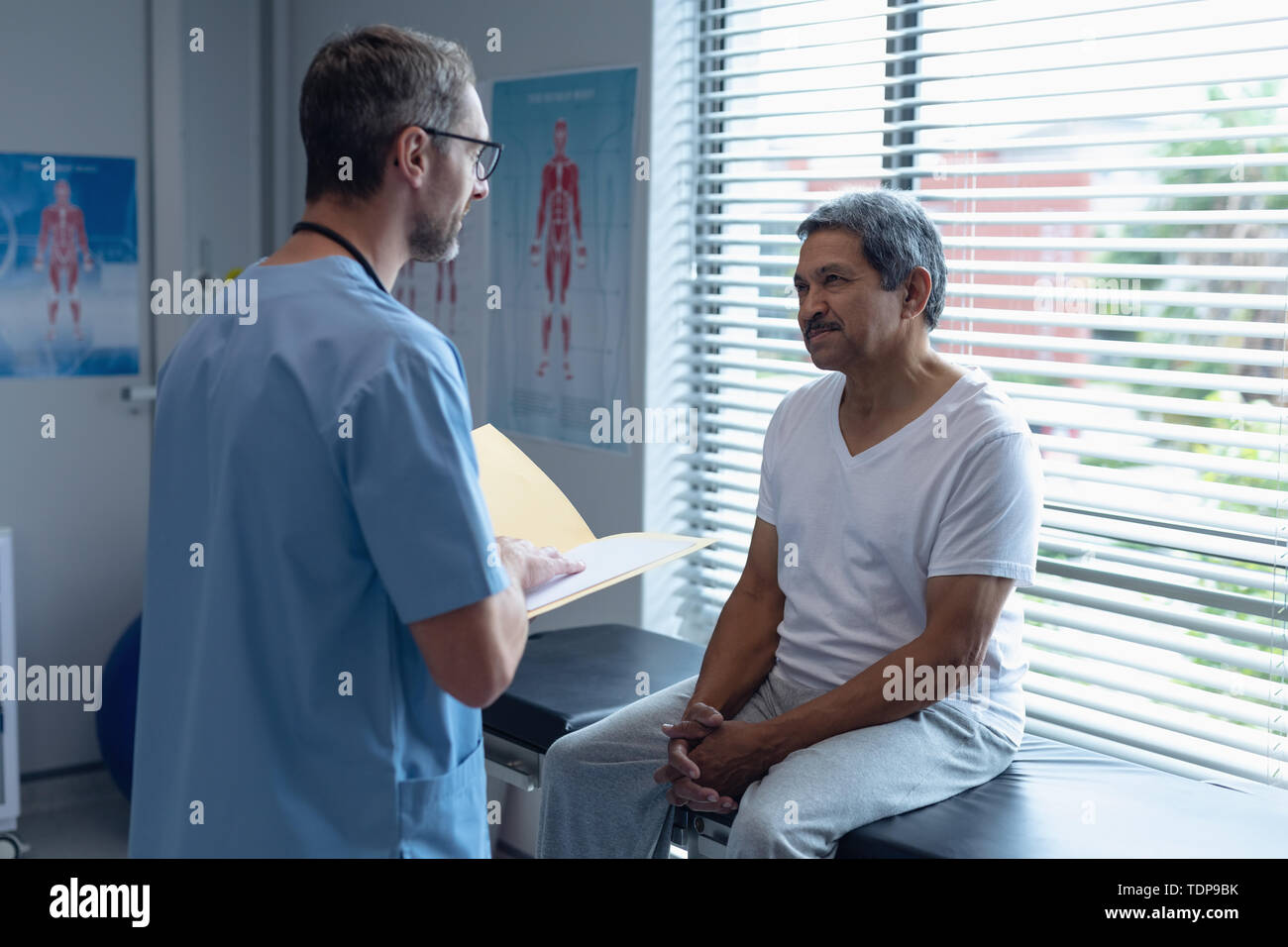 Male surgeon interacting with patient in hospital Stock Photo