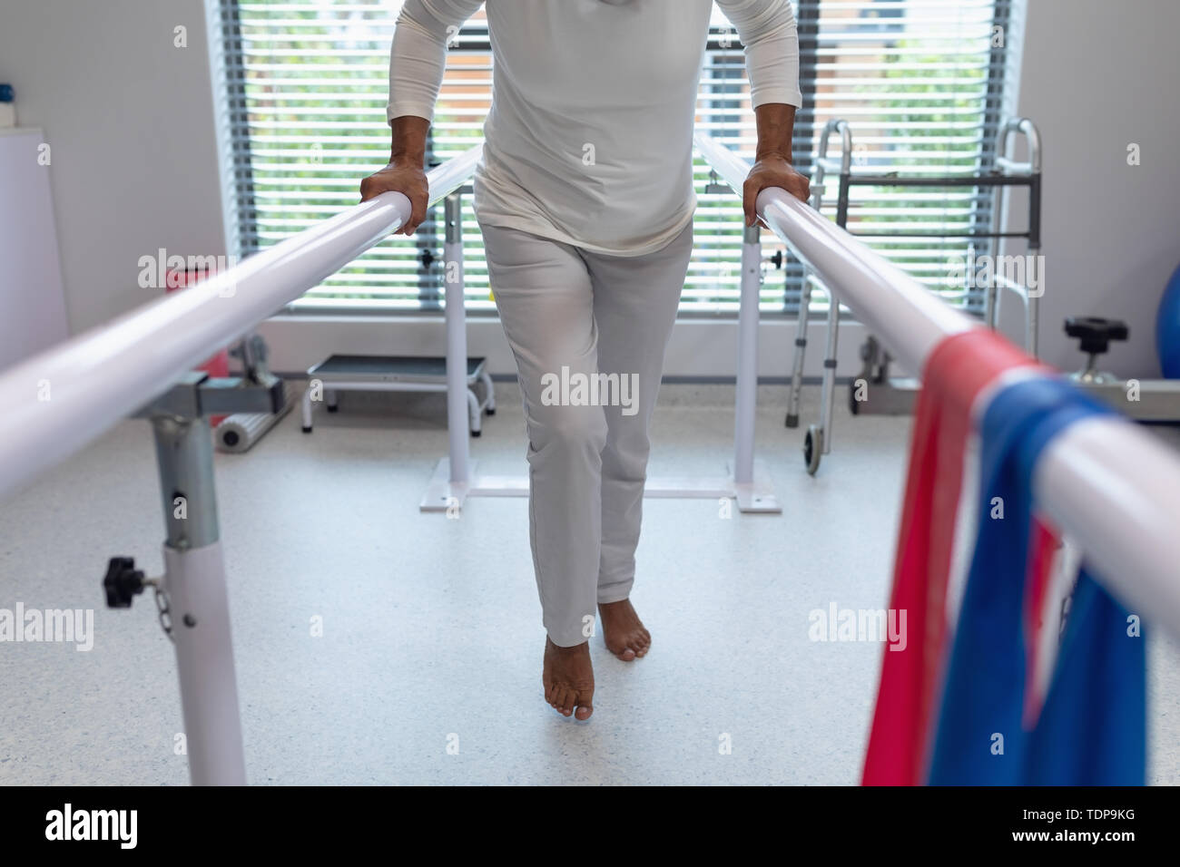 Female patient walking with parallel bars in hospital Stock Photo Alamy