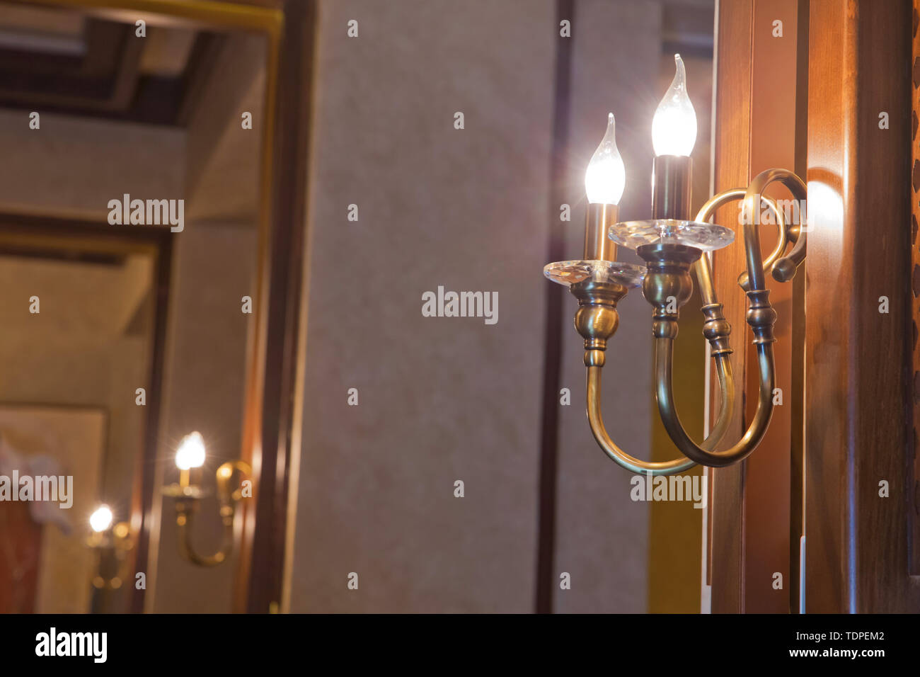 Retro copper candlestick hanging on the wall. Vintage golden