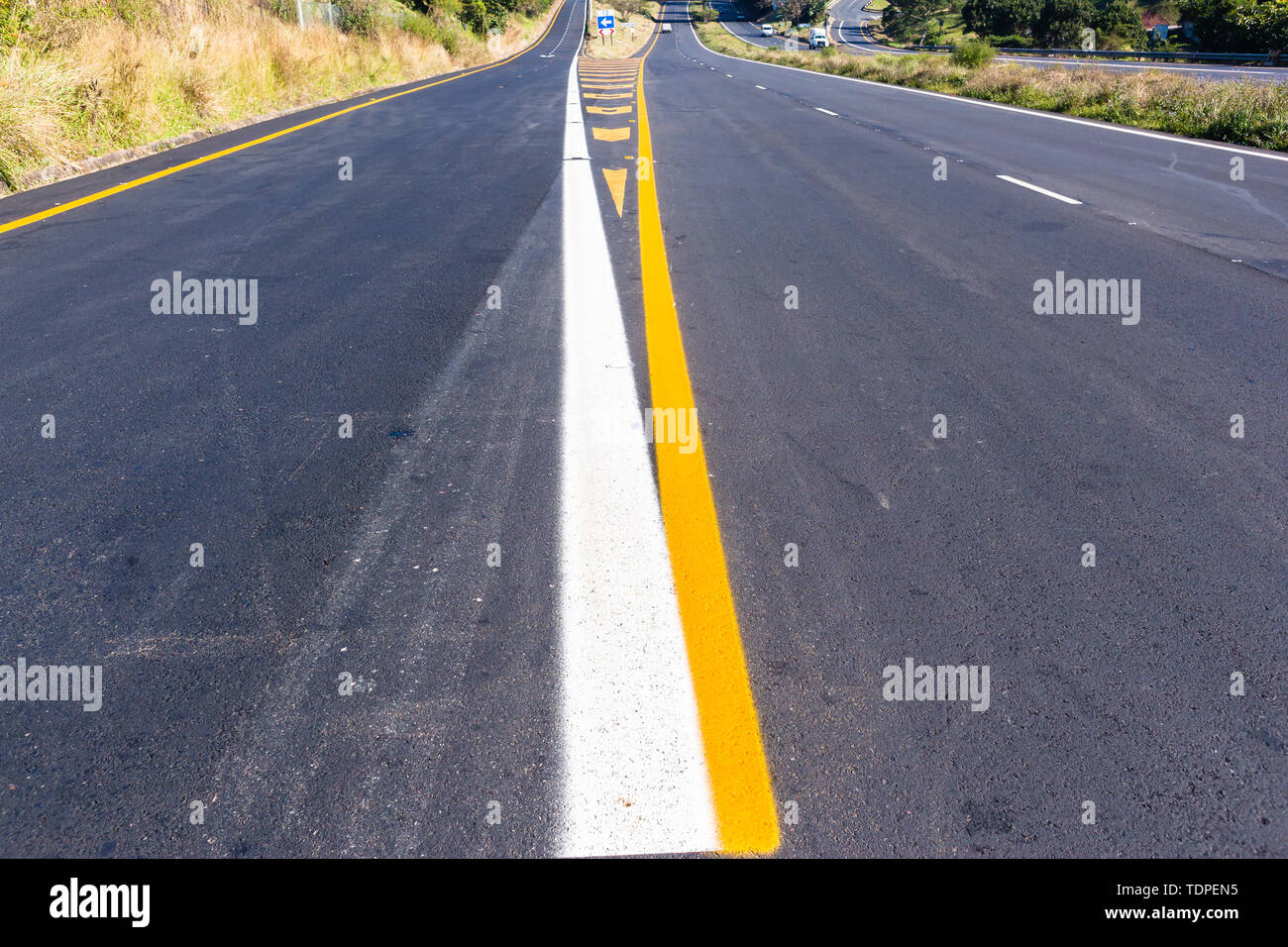 Road highway new asphalt tarmac painted white yellow exit markings directions lines closeup middle overhead photo detail. Stock Photo