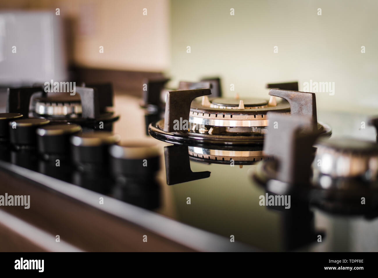 A clean and shiny cooker hob and knobs. Taken inside with golden light