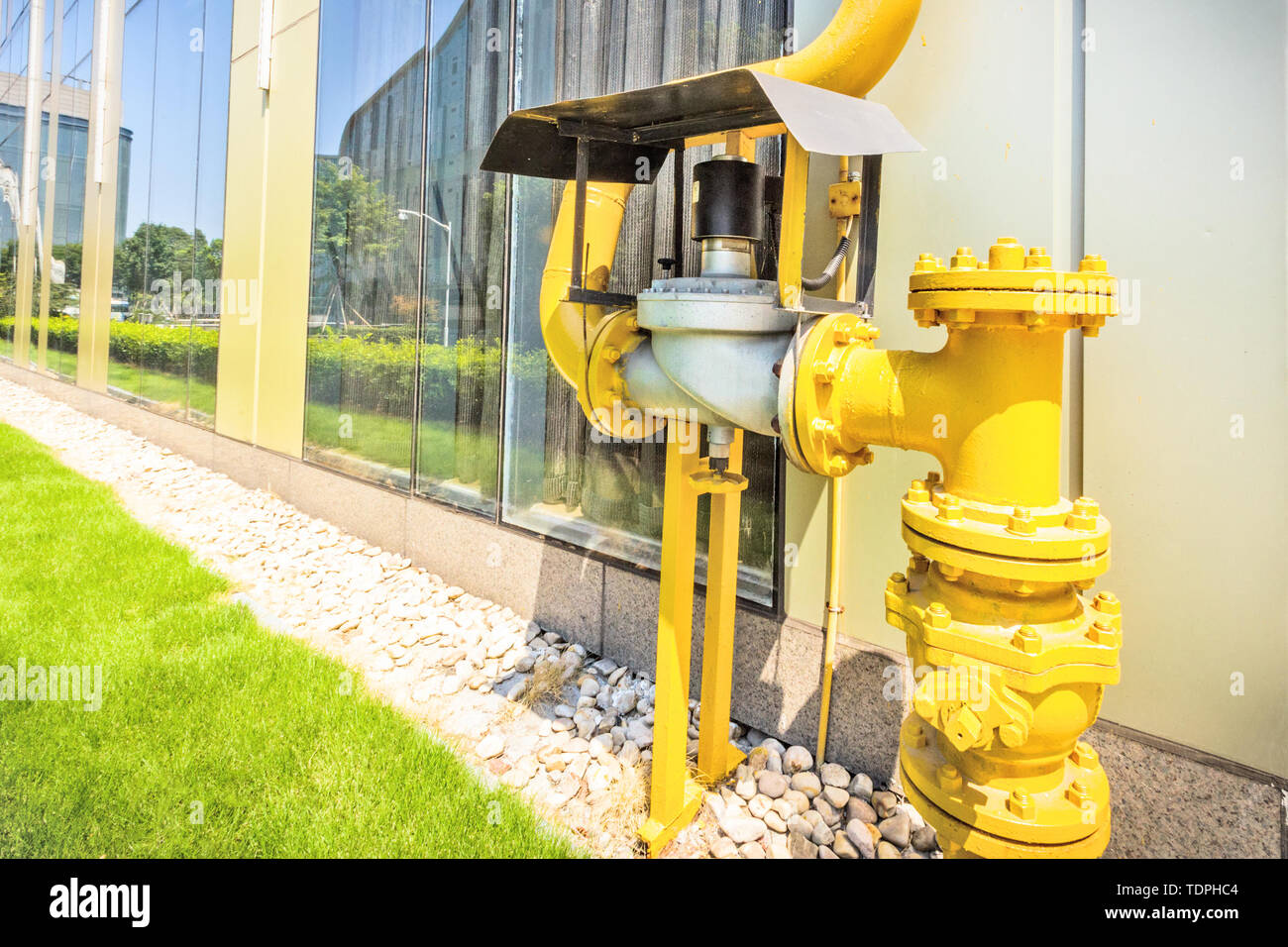 water pumps near green path in the corner of a building under sunshine