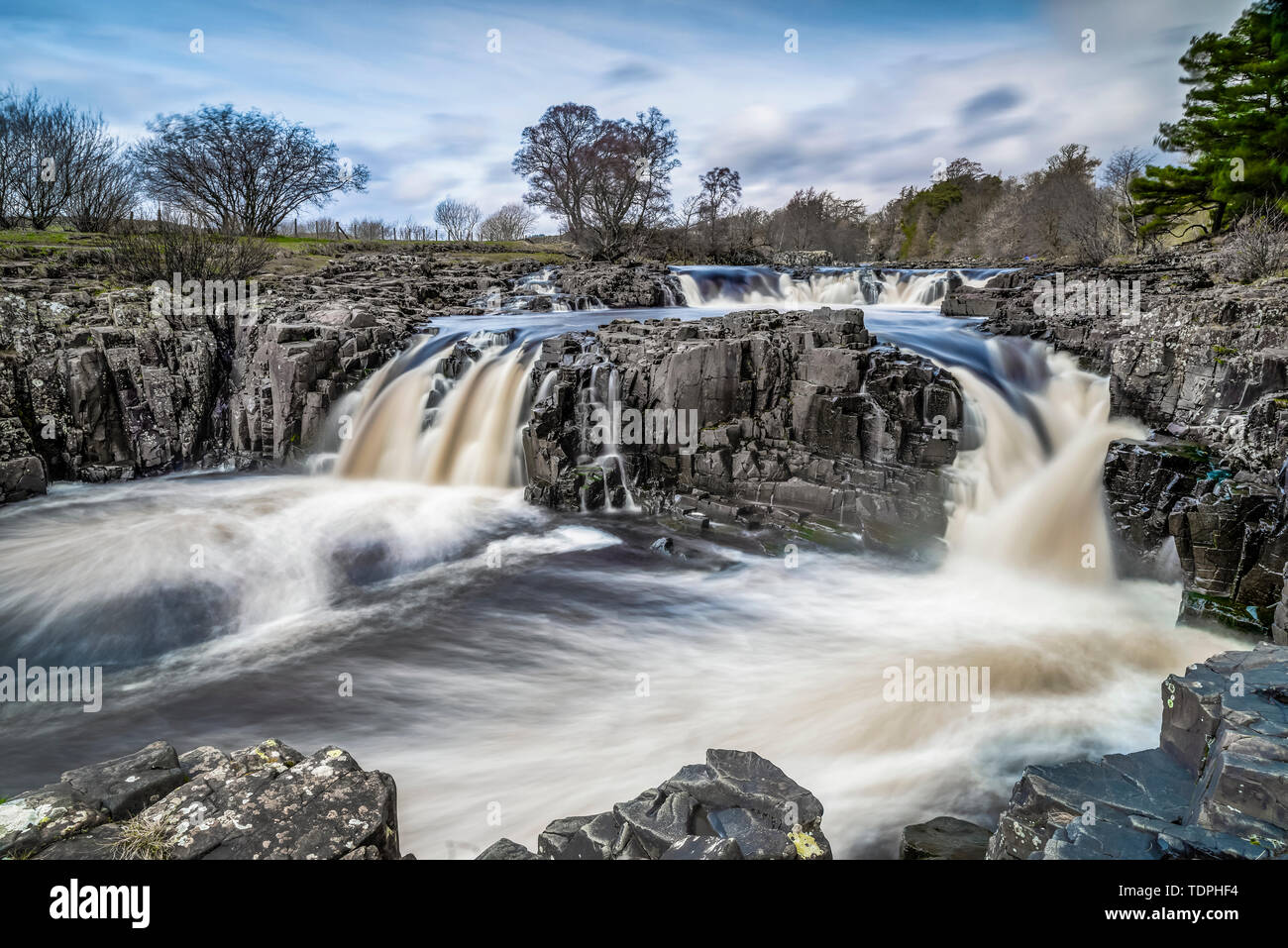 Low Force in Upper Teesdale, North of England where the River Tees tumbles over the Whin Sill, a layer of hard dolerite rock which formed 295 milli... Stock Photo