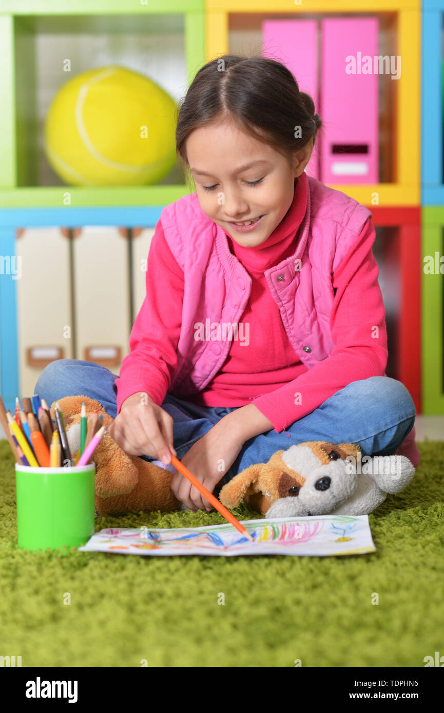 Portrait of cute little girl sitting on floor Stock Photo - Alamy